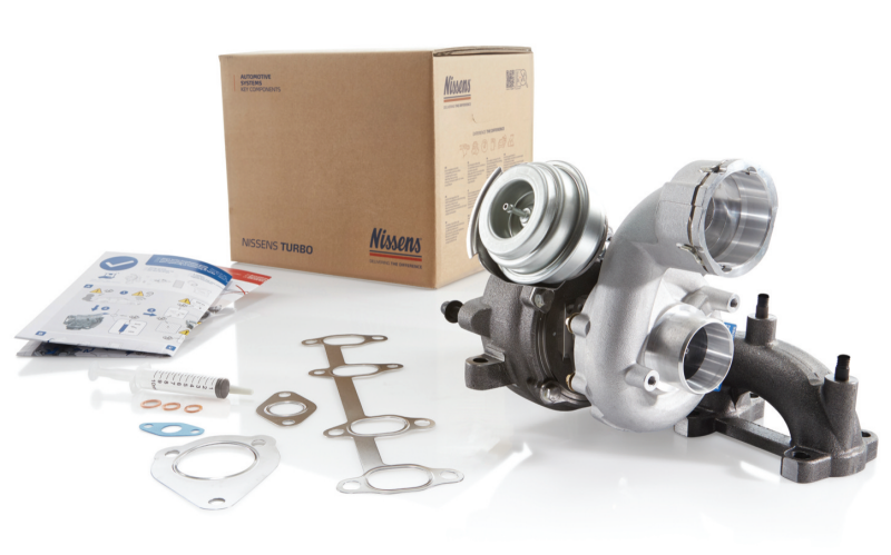 Nissens replacement turbocharger kit displayed alongside its original packaging box, installation instructions, oil priming syringe, and set of mounting gaskets and seals.