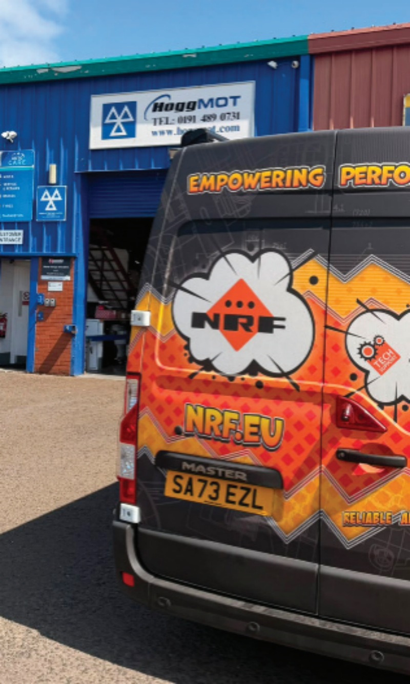 Rear view of an NRF branded Renault Master support van parked outside a Hogg MOT service station garage.