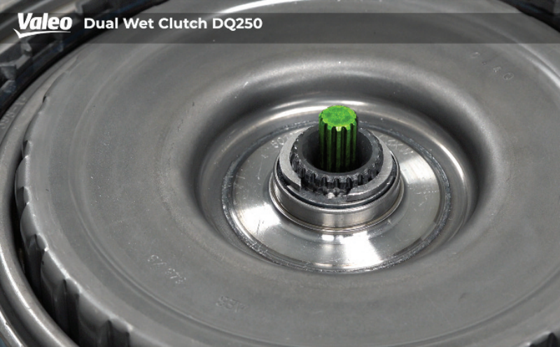 Close-up, top-down view of a Valeo Dual Wet Clutch DQ250 transmission assembly, focusing on the center input shaft splines coated with green grease and surrounded by the release bearing and clutch cover plate housing.