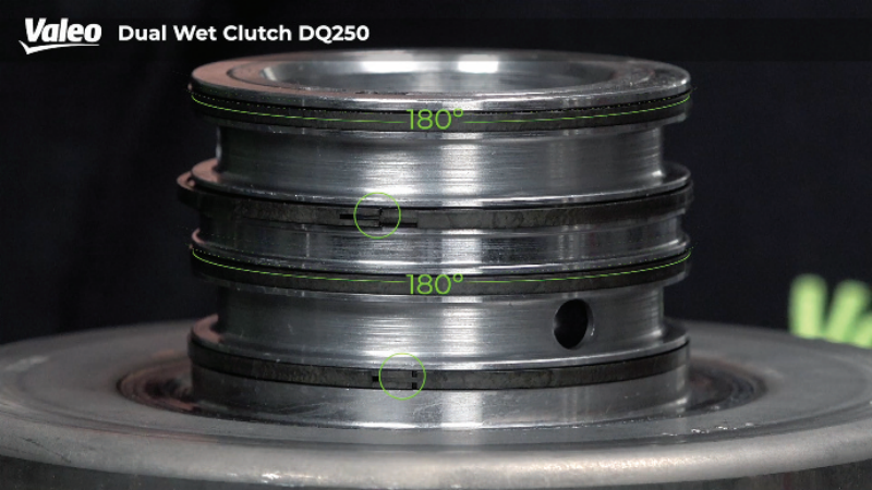 Close-up studio view of the Valeo Dual Wet Clutch DQ250 assembly highlighting the hydraulic piston hub with stacked sealing rings, annotated with green alignment markers showing a 180-degree offset between the ring gaps.
