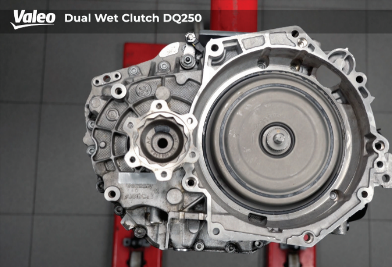 Top-down studio view of the fully reinstalled Valeo Dual Wet Clutch DQ250 assembly mounted on a red workshop stand, showing the finalized clutch cover, internal housing alignment, and differential output flange